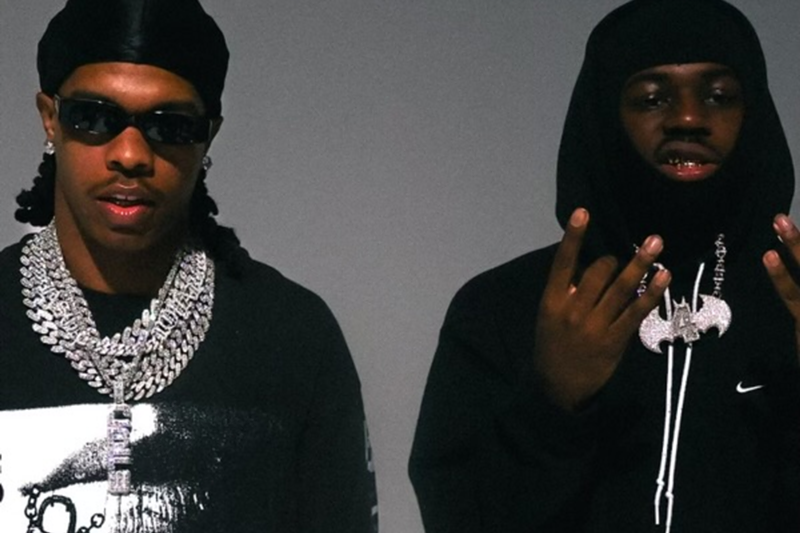 Image: Two men with chains staring at the camera