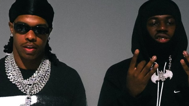 Two men with chains staring at the camera