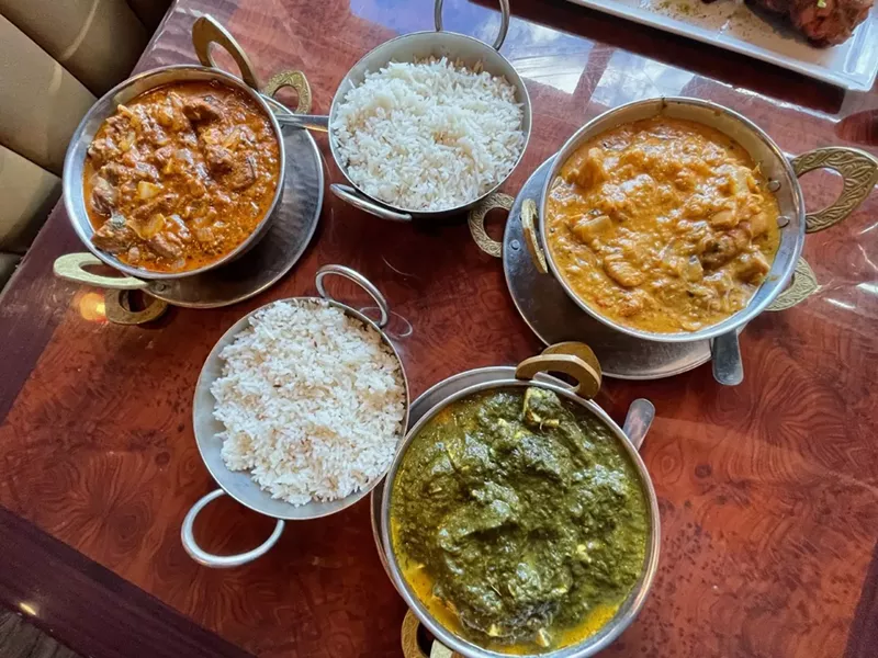 Image: Lamb rogan josh (top left), saag paneer (bottom right) and chicken korma (top right).