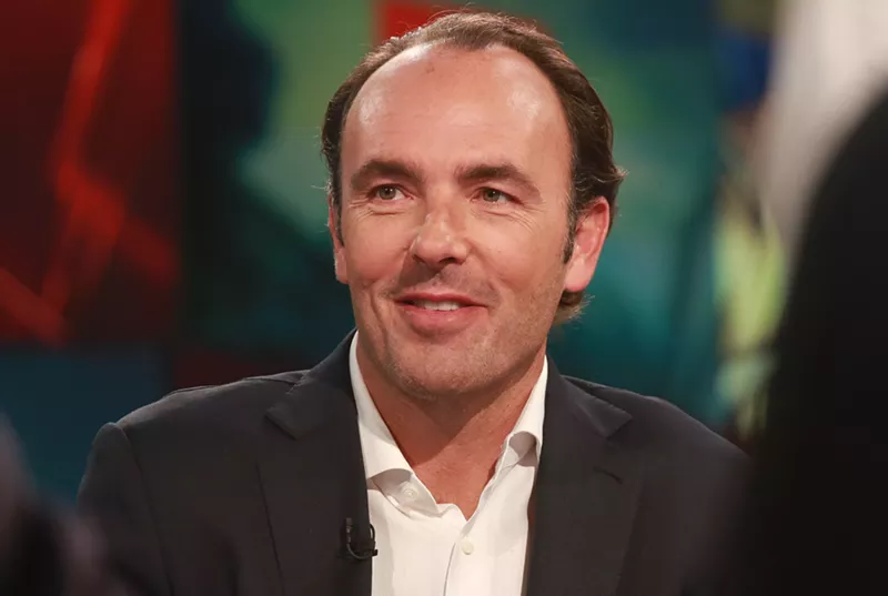 Image: Dallas billionaire Kyle Bass is seen smiling in a suit. This week he became the subject of ridicule after complaining for his room service charges.