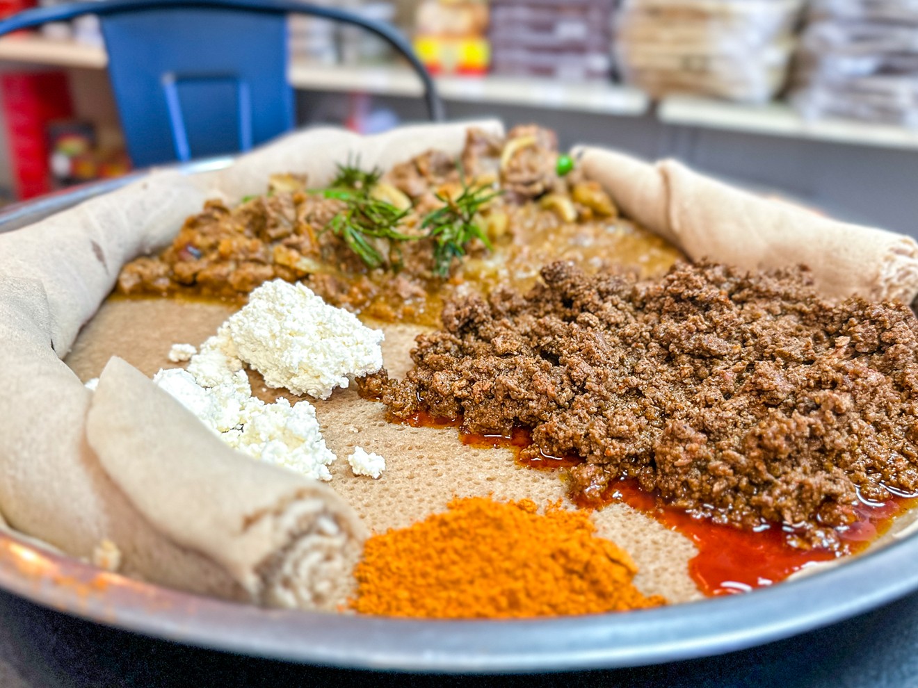 Lamb tibse and beef kitfo share a platter with injera and house-made cheese at Agoza Kitchen.