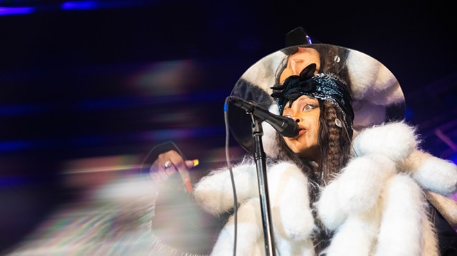 Erykah Badu in a white fur coat, celebrating her birthday bash in her signature mirrored top hat back last February at The Factory.