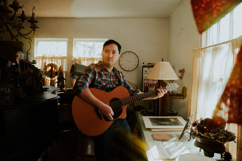 Image: man playing guitar at home