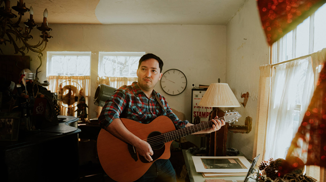 man playing guitar at home