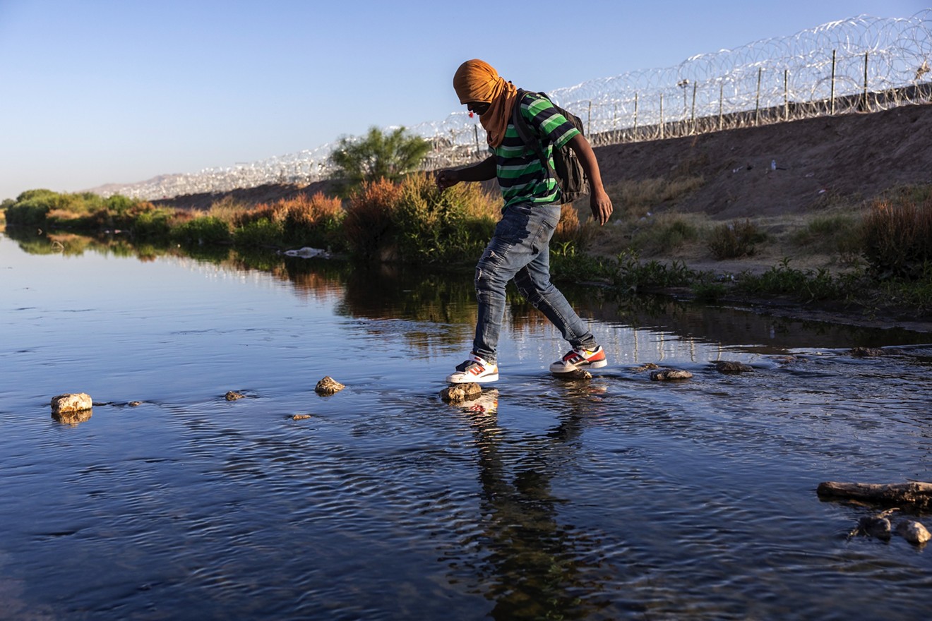 An immigrant walks across the shallow Rio Grande at the U.S.-Mexico border at El Paso on May 12, 2023.