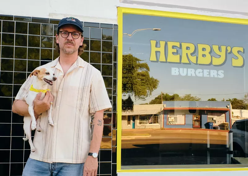 Image: Dallas' DJ Sober poses in front of his new joint, Herby's, with OG Herby, his dog.