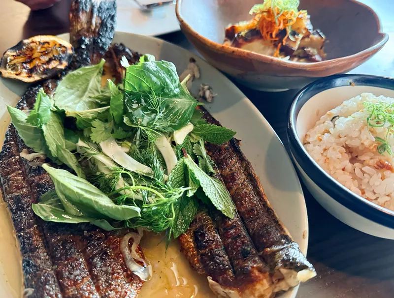 Image: The post oak grilled sea bass sizzles at Uchiko.