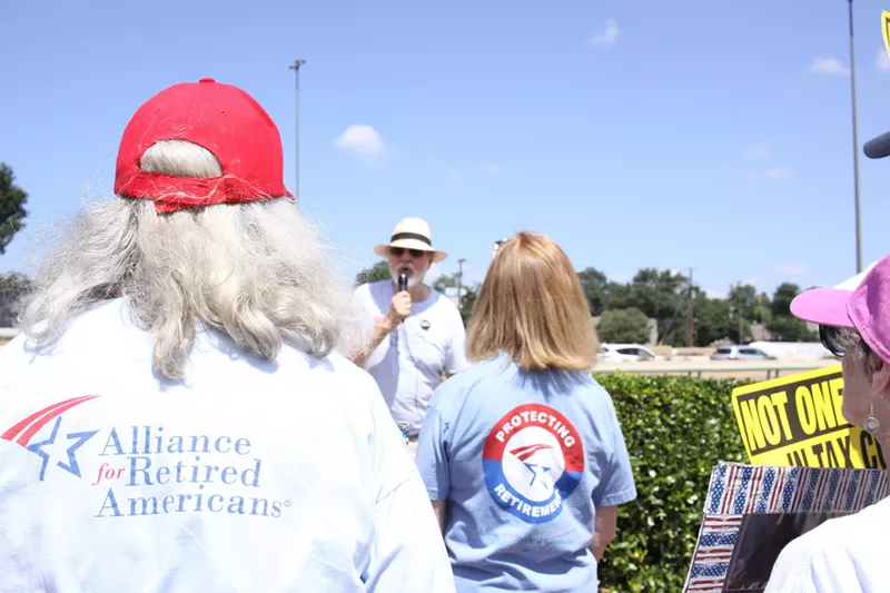 Image: Gene Lantz, state president of the Texas Alliance for Retired Americans, speaks to a group outside a Social Security office in Dallas on June 22.