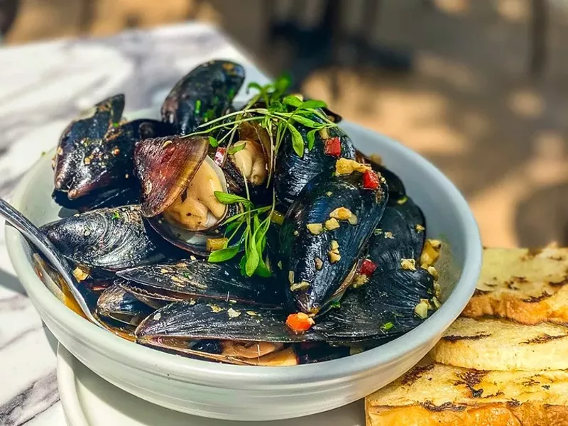 Image: Spicy Thai-style mussels with grilled bread to sop a rich broth.
