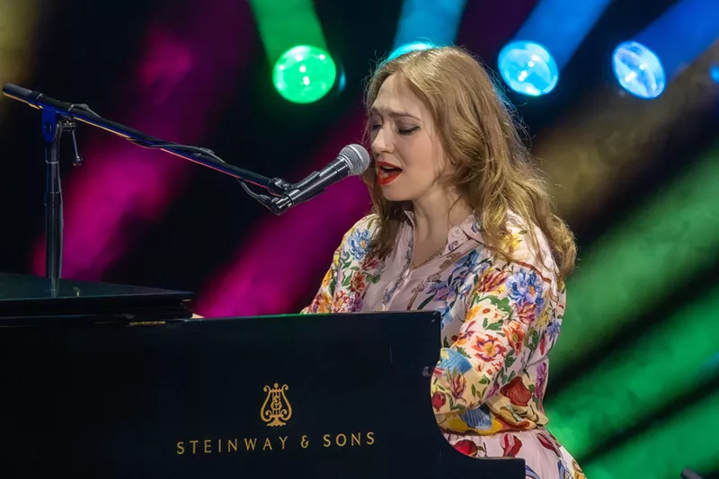 Image: A woman singing on a piano