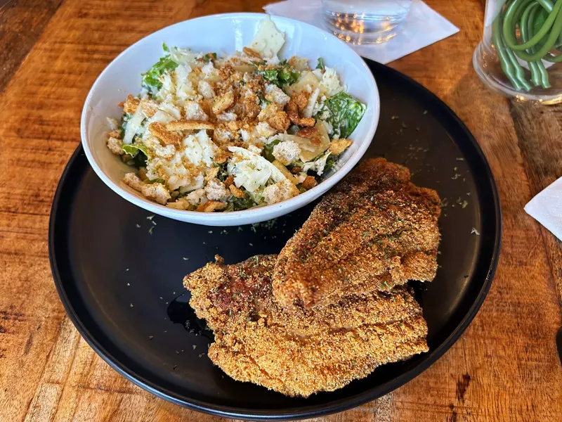 Image: The catfish at Party of 5 is generously seasoned with your choice of a side.