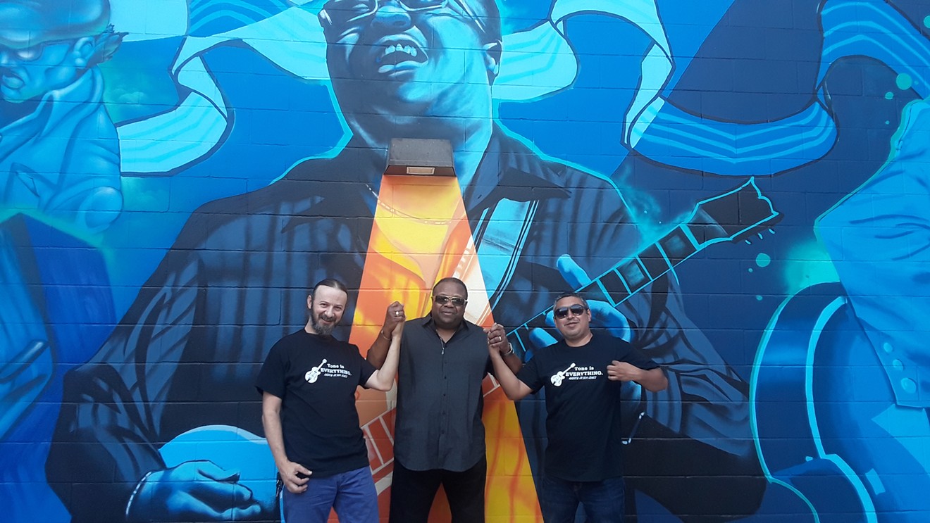 From left to right: Dan Colcer with artist Hatziel Flores with musician Andrew Jr. Boy Jones, in front of a mural belonging to Blues Alley.