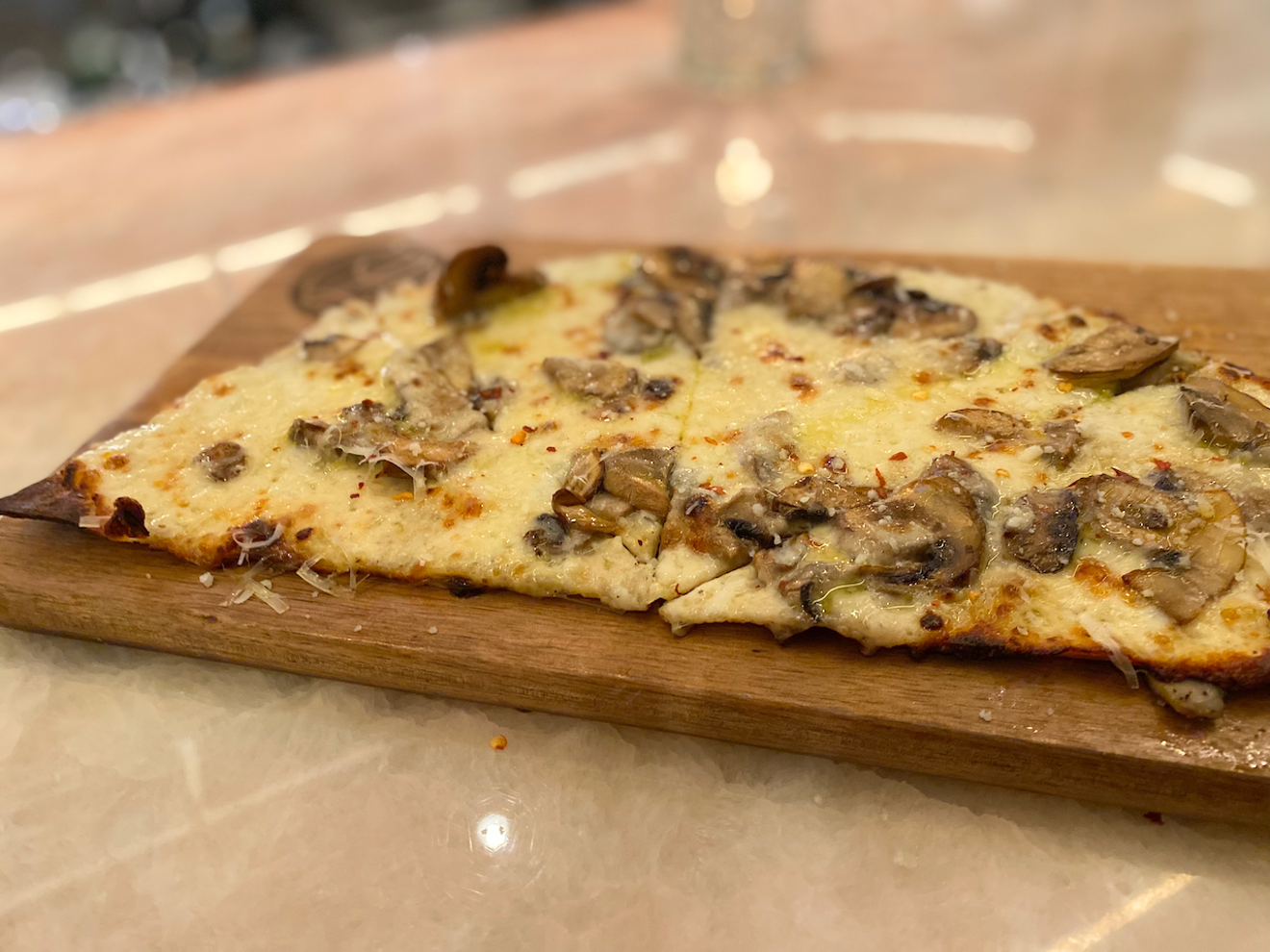 Half a Roman Tonda-style pizza with a thin, cracker-like crust.