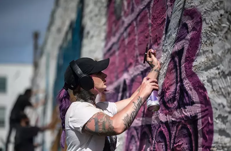 Image: Artist Minqs works on her wall at the 2023 version of Trigger Finger, a graffiti jam that's coming to Trinity Groves on April 5.