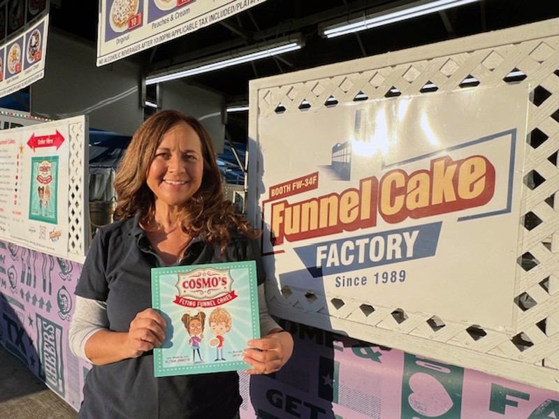 Author Allyson Jannotta holds her first published book, children's story Cosmo’s Flying Funnel Cakes.