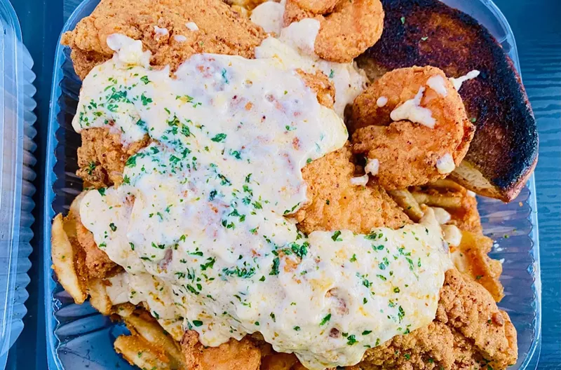 Image: The Bells Bayou Box comes with waffle fries, shrimp, fish smothered in a creamy seafood sauce.