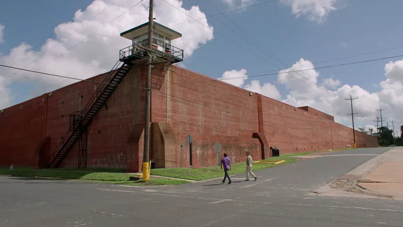 Image: Richard Linklater walks with an unknown subject to a prison in Huntsville. The Texas filmmaker examines the prison industry in God Saves Texas.