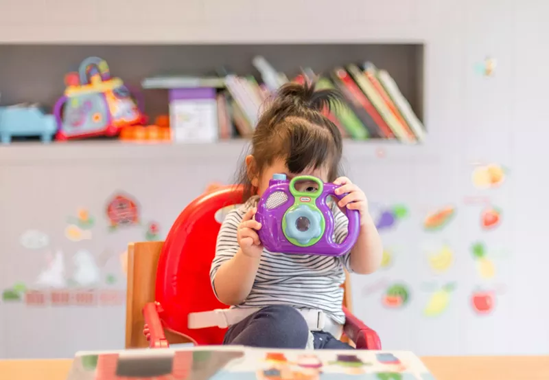 Image: A girl in a daycare class plays with a toy.