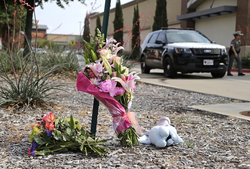 Flowers and a stuffed animal are left at the scene on May 7, the day after a shooting at Allen Premium Outlets. \