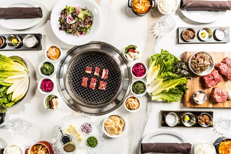 Image: A grill is the center of each table, creating a community experience.