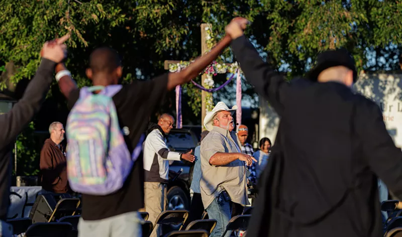 Image: Pastor Leon Birdd preaches to his congregation, which meets outdoors on Sunday mornings.