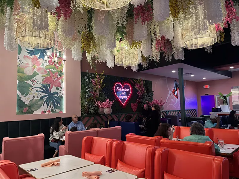 Image: The Dream Tacos dining room is decorated in flower garlands and bright lounge chairs.