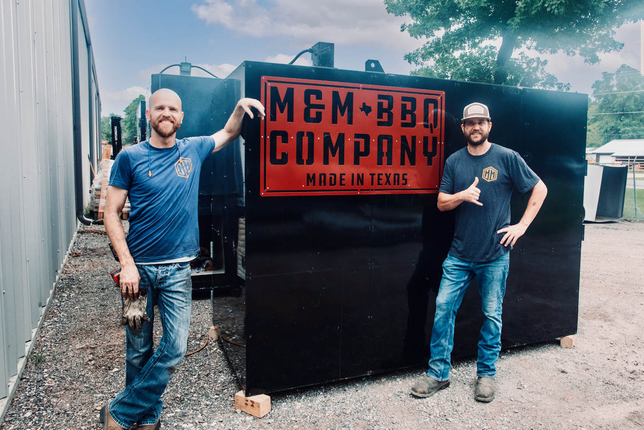 Matt Sutton (left) and Mike Miller flank one of their flagship rotisserie smokers at M&M BBQ Company.