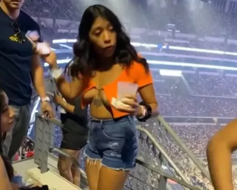 Image: An unidentified woman gets a group of friends to leave her assigned seats before the Bad Bunny show at AT&T Stadium.