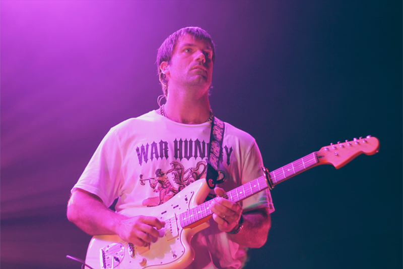 Image: Man performing with guitar on stage