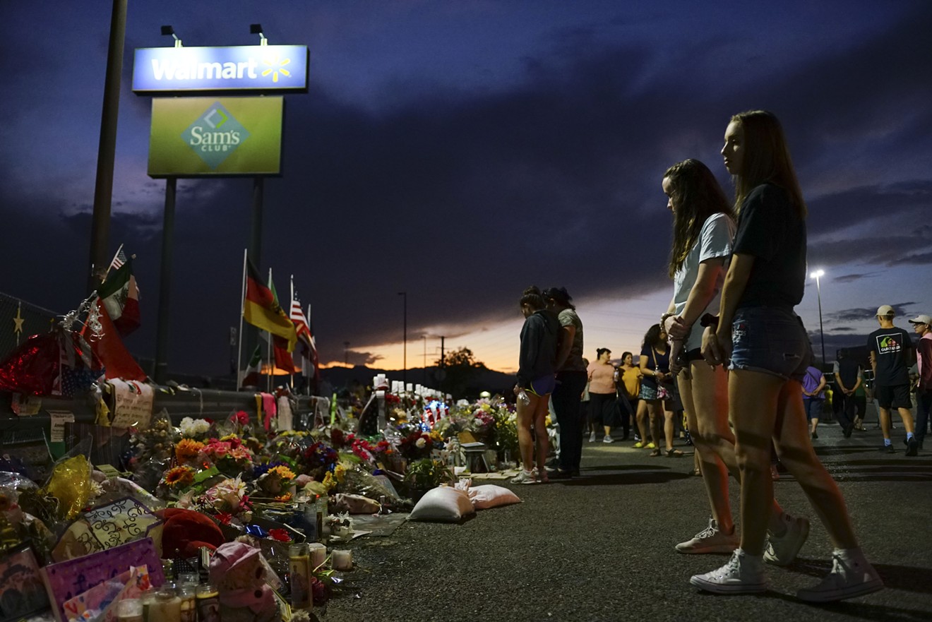 People gather at a makeshift memorial honoring victims of a mass shooting outside Walmart on Aug. 15, 2019, in El Paso.