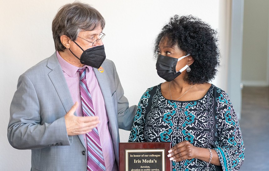 Collin College history professor Dr. Michael Phillips presents a plaque honoring Iris Meda. - SIMONE CARTER