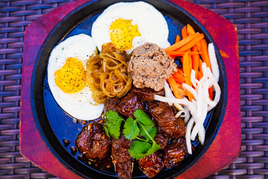 Bò né is served on a sizzling plate and is a Vietnamese version of steak and eggs. - COURTESY OF PHILLIP DANG