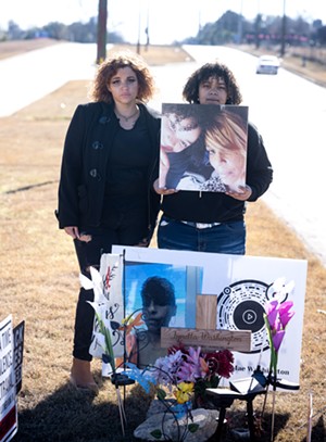 Angel Durr and Myah Hill stand behind a memorial to their mother, Lynetta Washington. - MIKE BROOKS