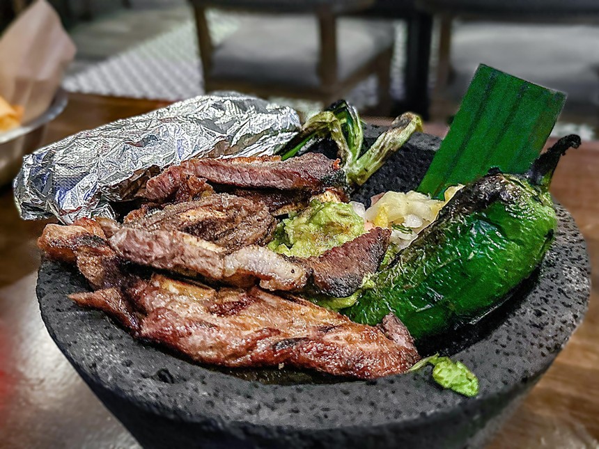 Black Agave's short rib tablitas are rojo beans, jalapeño, queso blanco, crema, guacamole and charred green onions in a molcajete.