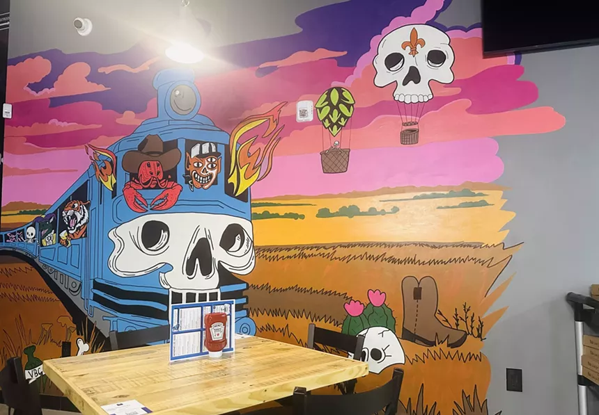A stricking mural created by local artist Andrea Holmes of a stylized train crossing a desert.