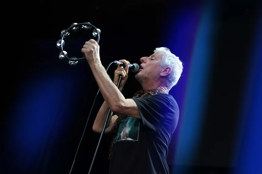 Man playing a tambourine on stage