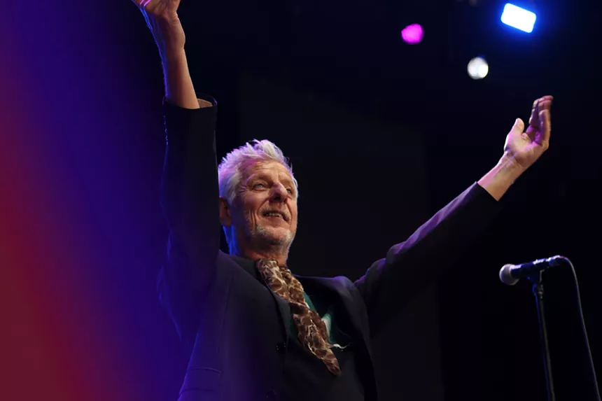 Man waving his hands on stage