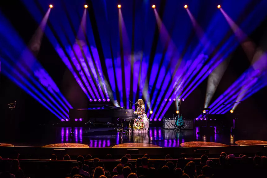 A woman singing on a piano