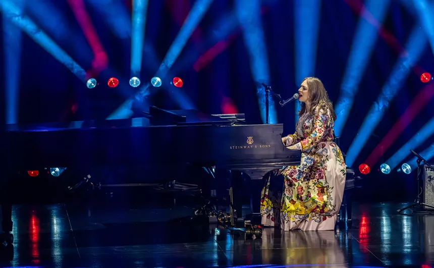 A woman singing on a piano