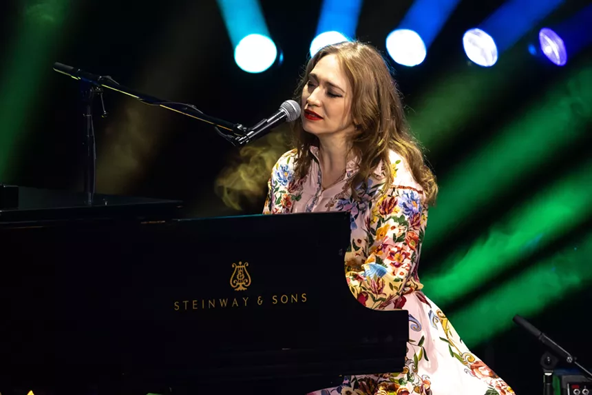 A woman singing on a piano