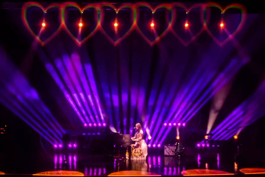 A woman singing on a piano
