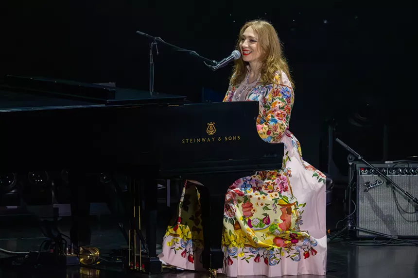 A woman singing on a piano