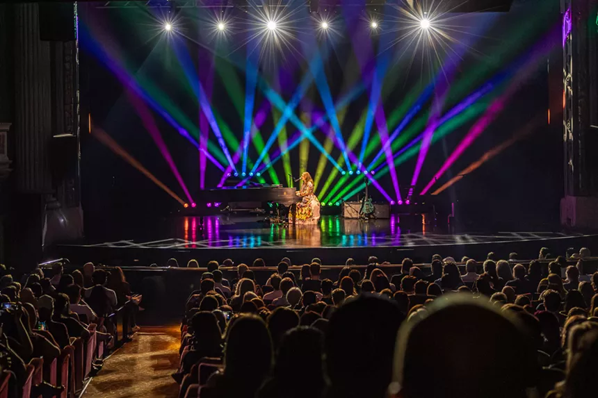 A woman singing on a piano