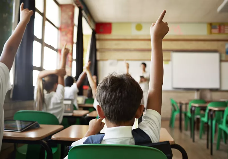 Image: Students raising hands in classroom
